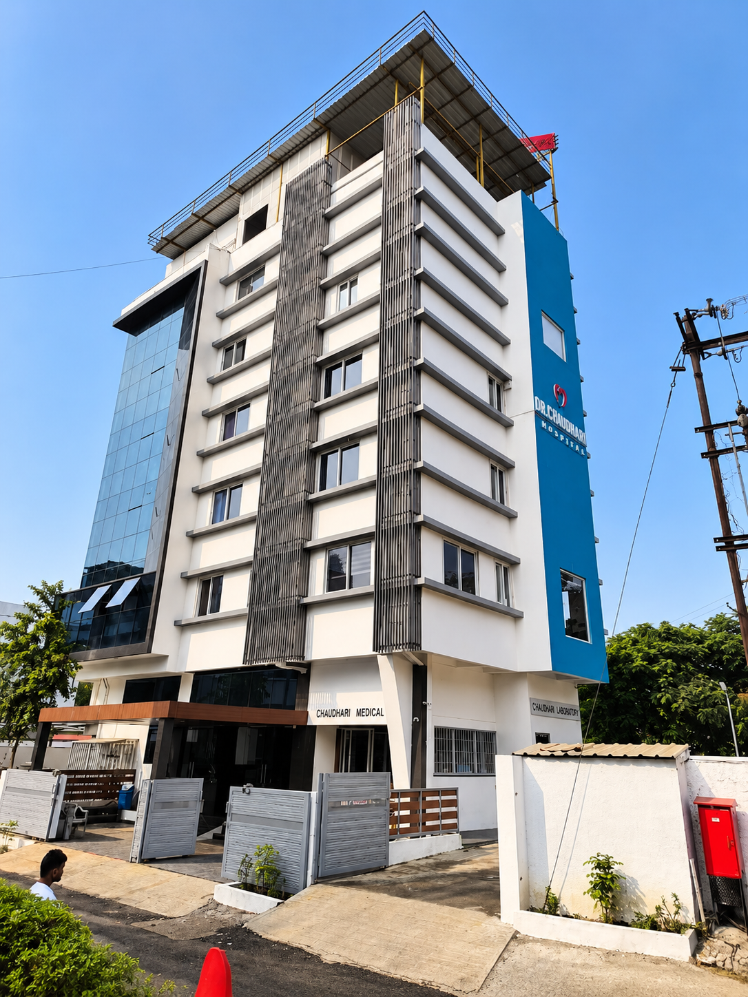 Dr. Chaudhari Hospital building with teal tower, seen from street level