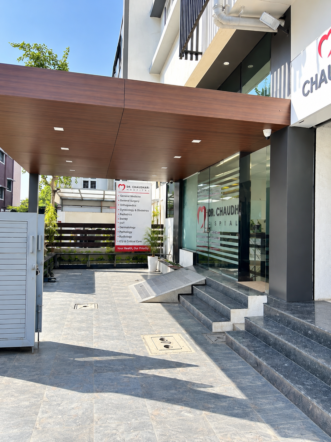 Covered entrance with wooden canopy, ramp, steps and departments signboard
