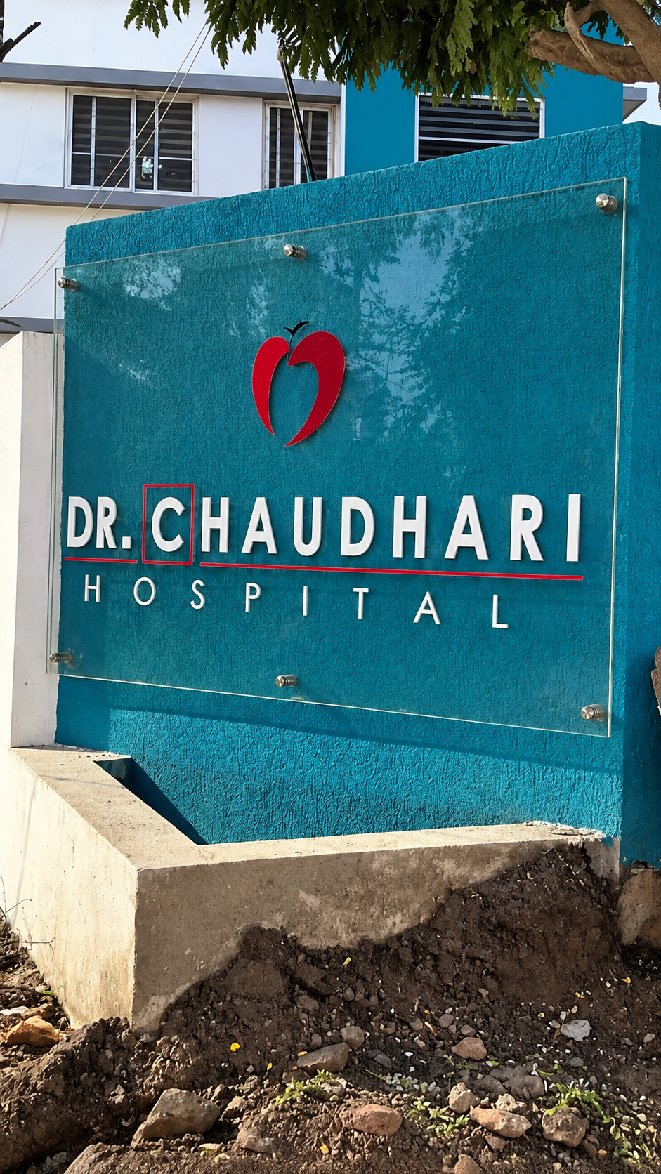 Teal entrance sign reading Dr. Chaudhari Hospital with red heart emblem